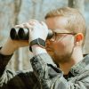 Hunter in glasses using Carson VX Series, best binoculars for hunting, 10x Magnification