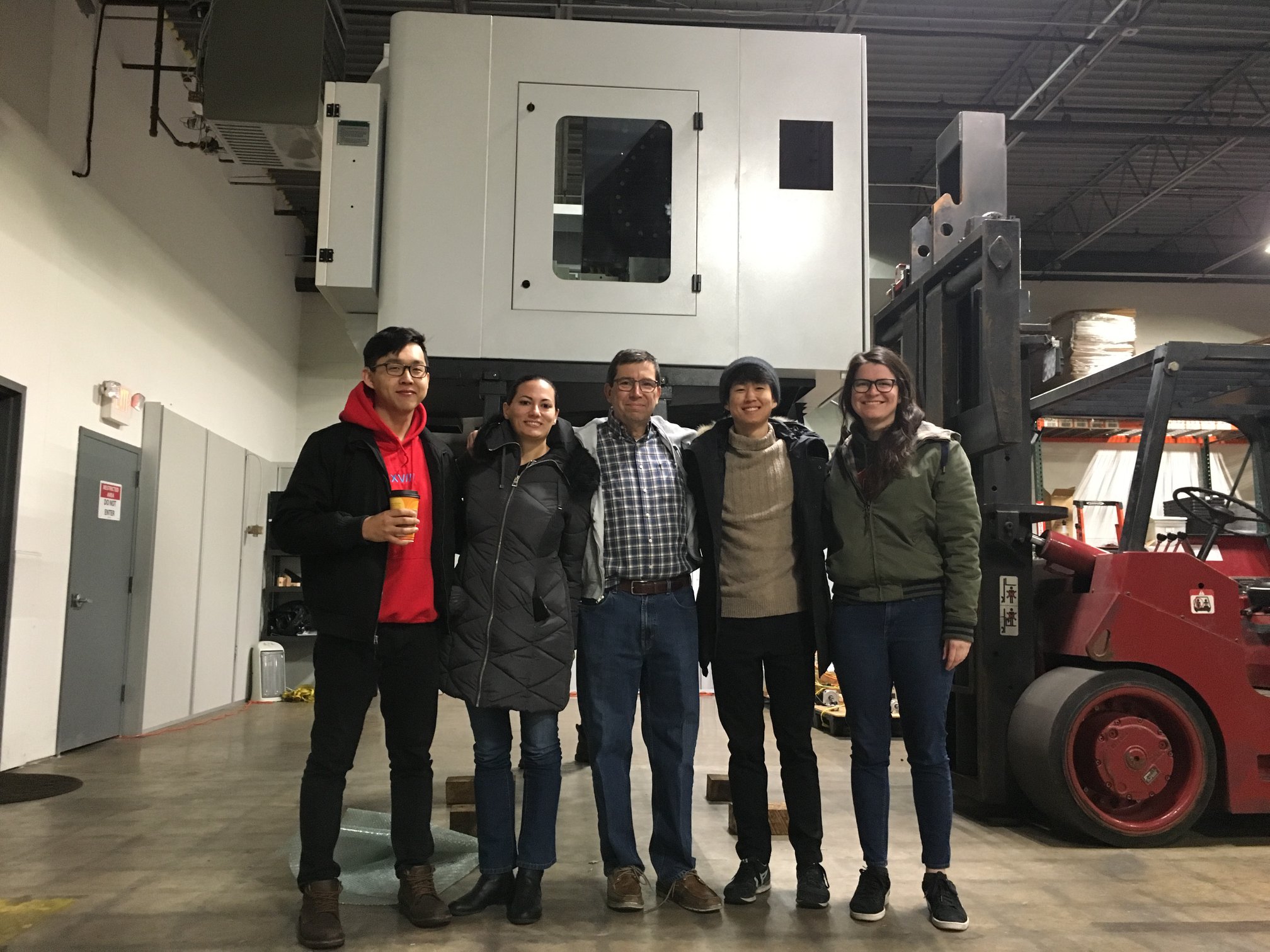 The founder and four employees standing in a warehouse