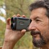 Hunter outdoors using RF-700 Carson LiteWave Pro Laser Rangefinder for accurate measurement in golf hunting archery or construction