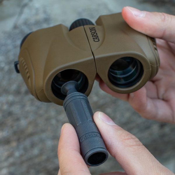 Cazador usando Limpiador de lentes reutilizable, portátil y liviano como herramienta de limpieza de lentes en binoculares compactos de Carson al aire libre mientras acampa en la naturaleza